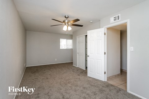 a bedroom with a ceiling fan and a door to a closet