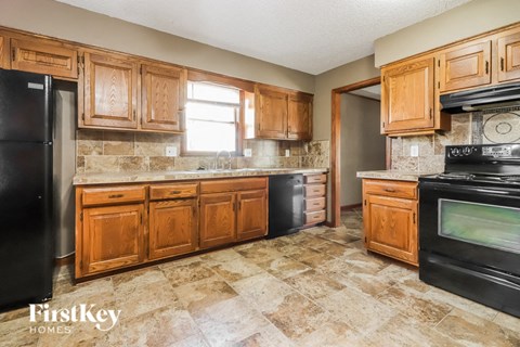 a kitchen with wooden cabinets and black appliances