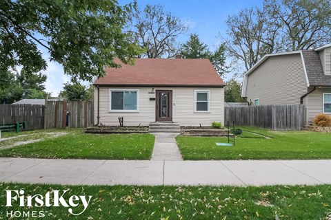 a small white house with a yard and a sidewalk