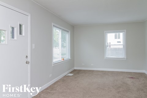 a room with a carpet and a door and two windows
