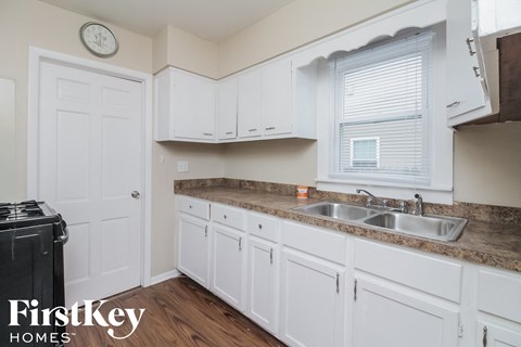 a kitchen with white cabinets and a counter top and a sink