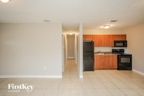 A kitchen with a black refrigerator and microwave.
