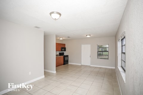 A spacious living room with a flat screen TV and a white ceiling.