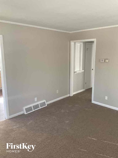 an empty room with a hallway and a door to a closet