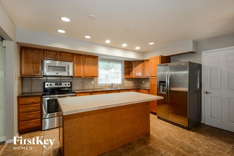 an updated kitchen with stainless steel appliances and wooden cabinets