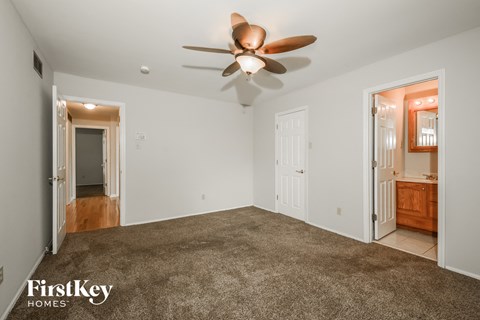 a living room with carpet and a ceiling fan