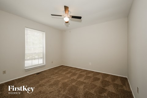 a bedroom with carpet and a ceiling fan