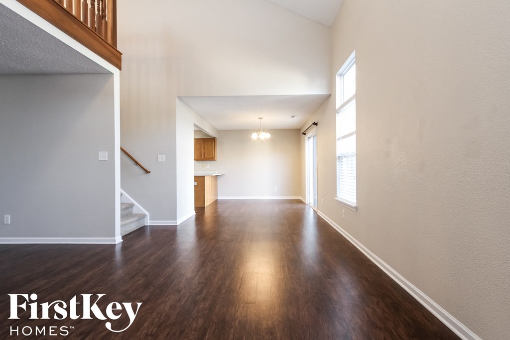 an empty living room with hardwood flooring and a staircase