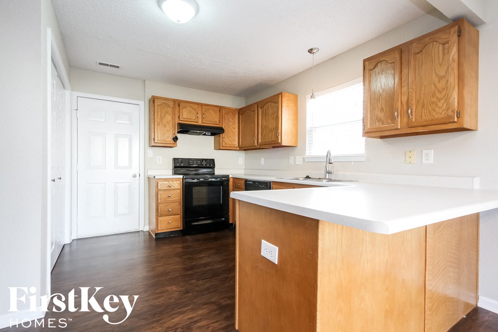 a kitchen with wooden cabinets and a white counter top