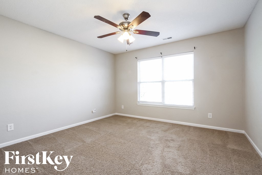 a bedroom with carpet and a ceiling fan
