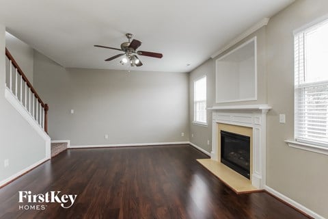 A spacious room with a fireplace and a ceiling fan.