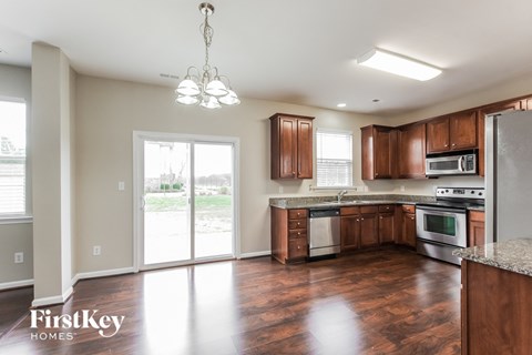 A kitchen with wooden cabinets and a stainless steel refrigerator.