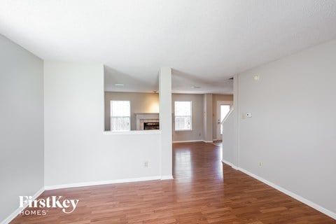 the living room and dining room with hardwood floors and white walls
