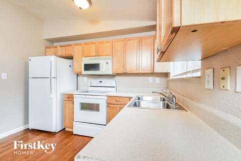 A kitchen with wooden cabinets and white appliances.