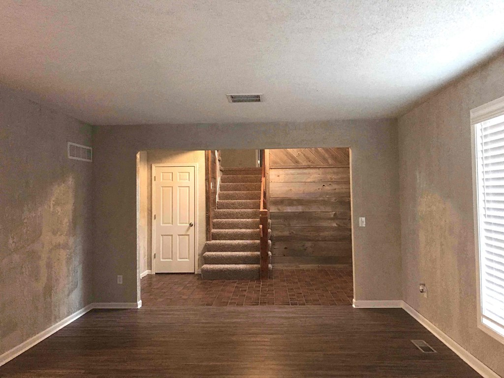 A room with a staircase leading to a wooden deck.