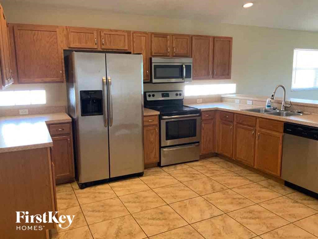 A kitchen with wooden cabinets and a tile floor.
