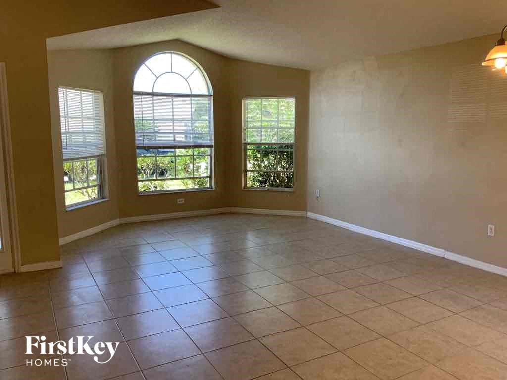A room with a tiled floor and a large arched window.