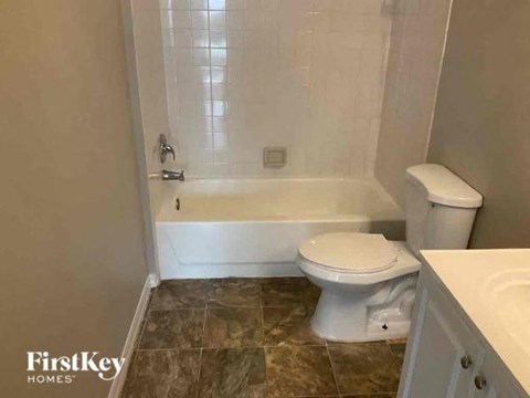 a bathroom with a toilet and a tub and a sink