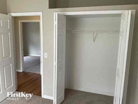 an empty bedroom with a closet and an open door
