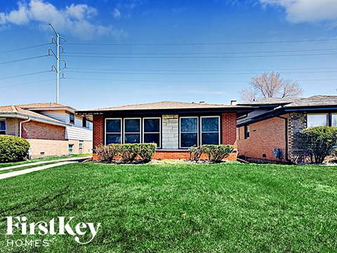 a small brick house with green grass in front of it