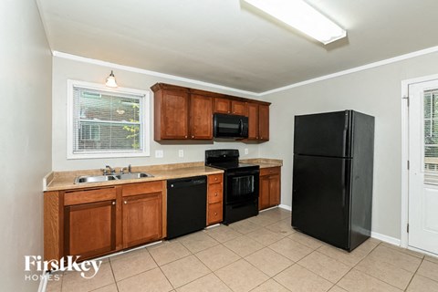 A kitchen with wooden cabinets and black appliances.