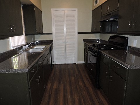 A kitchen with dark cabinets and a white door.