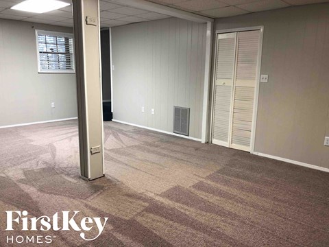 a living room with carpet and a door to a closet