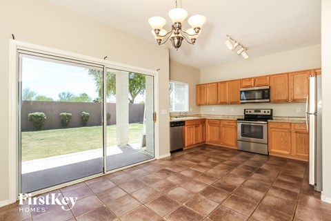 A kitchen with brown tiles and wooden cabinets is shown.