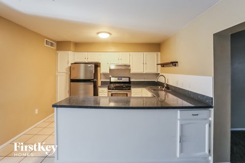 A kitchen with a white counter and cabinets.