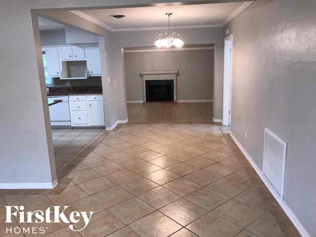 A spacious room with a fireplace and tiled flooring.