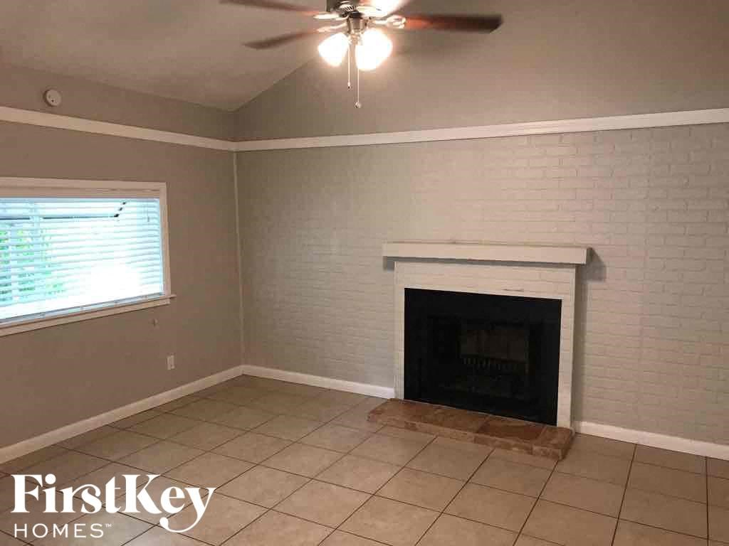 A room with a fireplace and a ceiling fan.