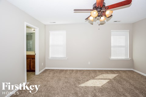 a living room with carpet and a ceiling fan