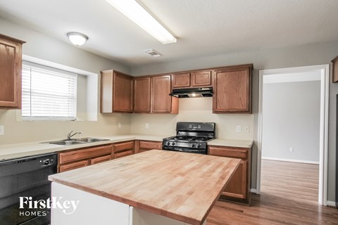 A kitchen with wooden cabinets and a wooden countertop.