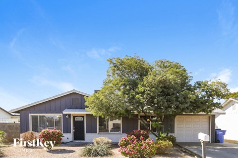 a house with a garage and a tree in front of it