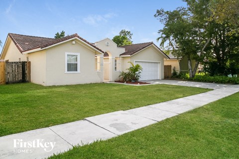 a home with a lawn and a sidewalk in front of it