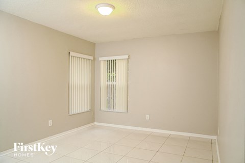 a spacious living room with white tile floors and a window