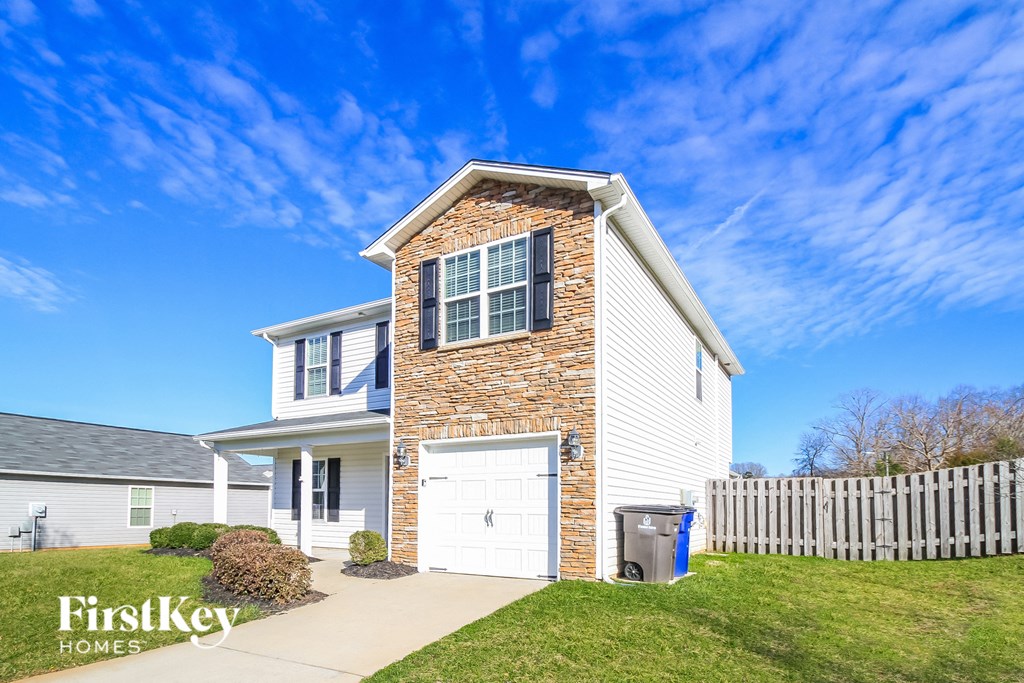 a white house with a white fence and a white garage door