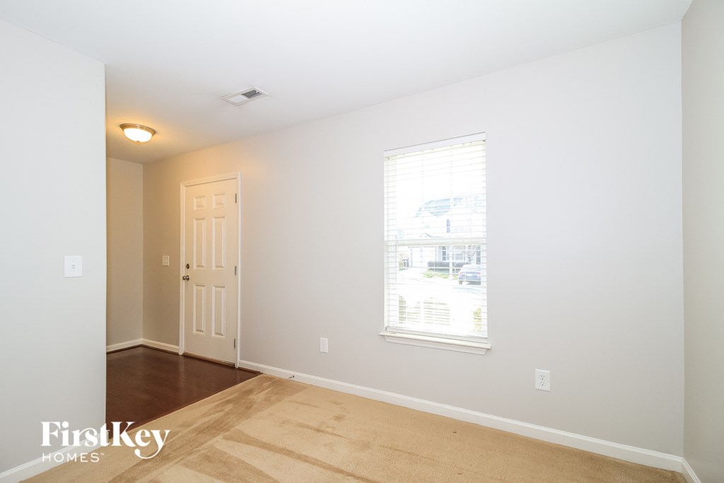 a bedroom with white walls and a window and a wooden floor