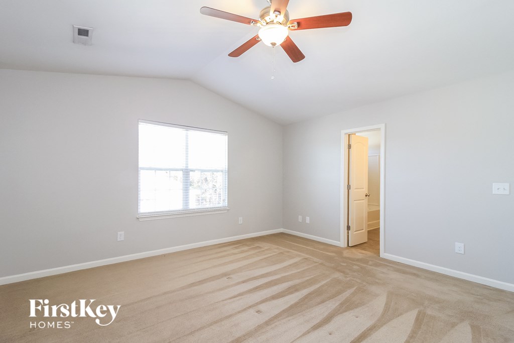 a bedroom with white walls and a ceiling fan
