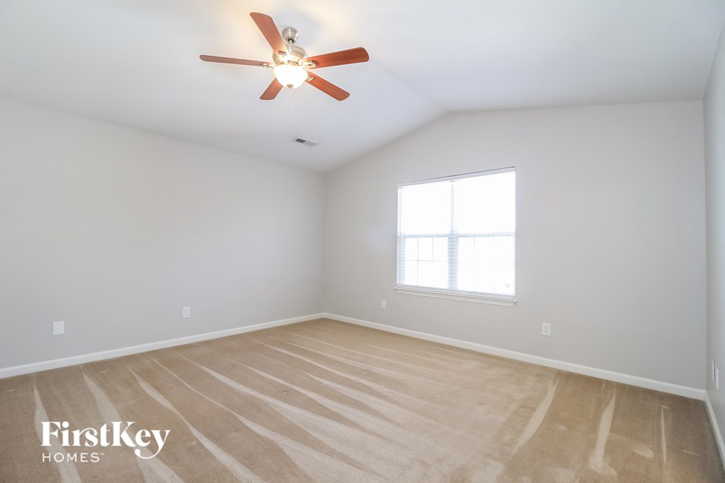 a bedroom with wood floors and a ceiling fan