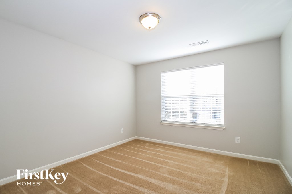 a bedroom with a window and a wooden floor
