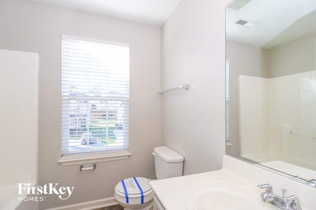 a bathroom with a mirror and a sink and a toilet
