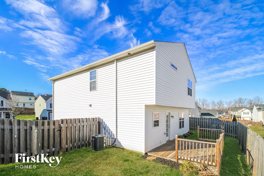 a white house with a fenced in yard and a fence
