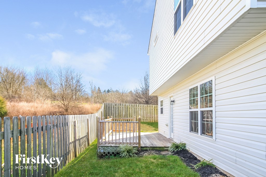 a white house with a wooden deck and a white fence