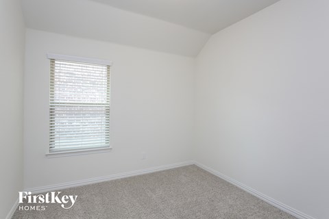 a bedroom with white walls and a window and a carpet