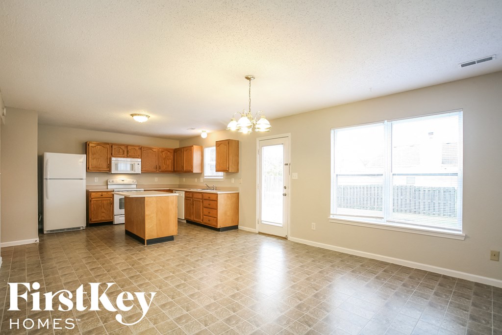 a kitchen with wood cabinets and white appliances and a large window