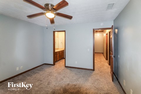 a bedroom with a ceiling fan and a mirror