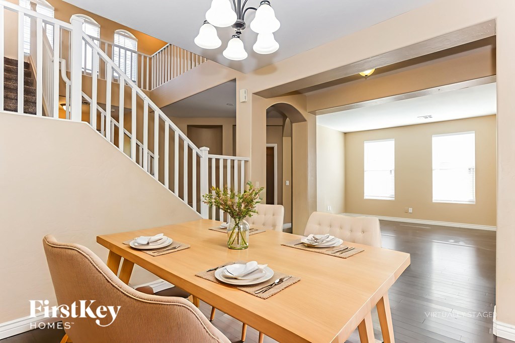 A dining room with a wooden table set for two.