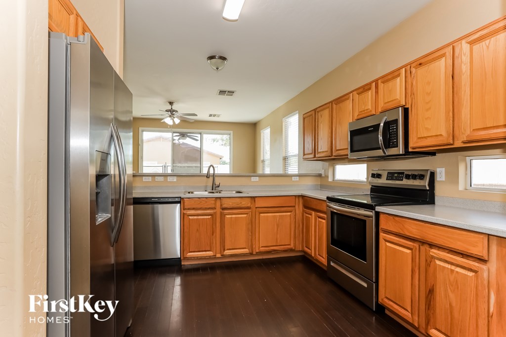 A kitchen with wooden cabinets and a stainless steel refrigerator.