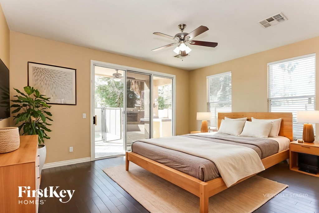A bedroom with a bed, nightstand, and a plant.